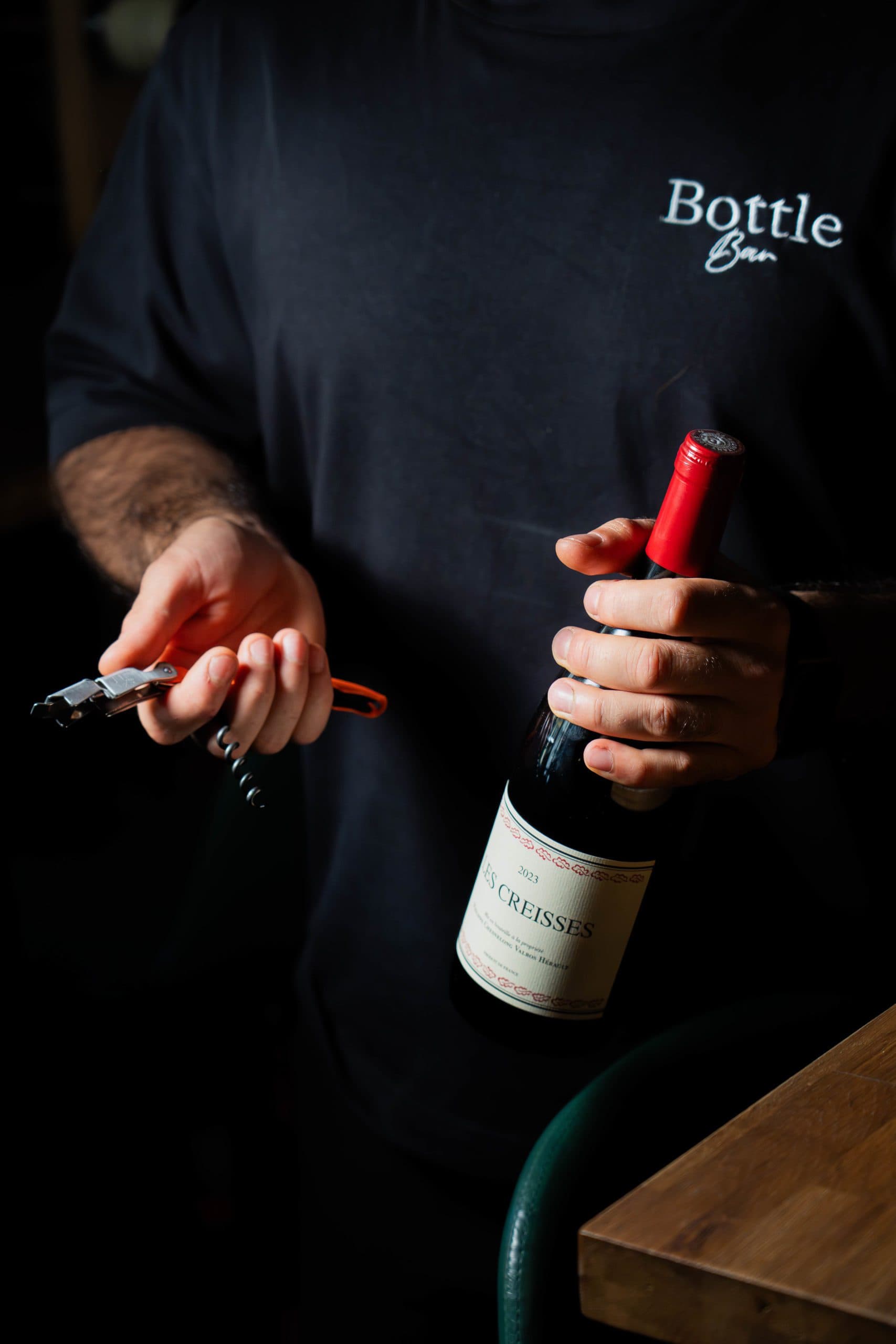 Notre sommelière ouvre une bouteille de vin pour la dégustation